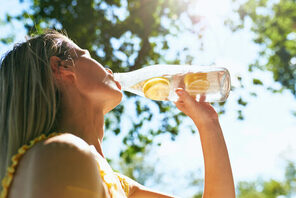 Frau trinkt aus einer Wasserflasche mit einer Zitrone © stock.adobe.com / Iuri Cazac