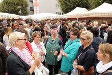 Besucher des Marktfrühstücks unterhalten sich bei einem Glas Wein